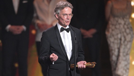 Ingo Fliess steht bei der Verleihung des Deutschen Filmpreises mit dem Preis für die "Lola in Gold" für den Film auf der Bühne. Ingo Fliess steht bei der Verleihung des Deutschen Filmpreises mit dem Preis für die "Lola in Gold" für den Film auf der Bühne. © picture alliance/dpa | Hannes P. Albert