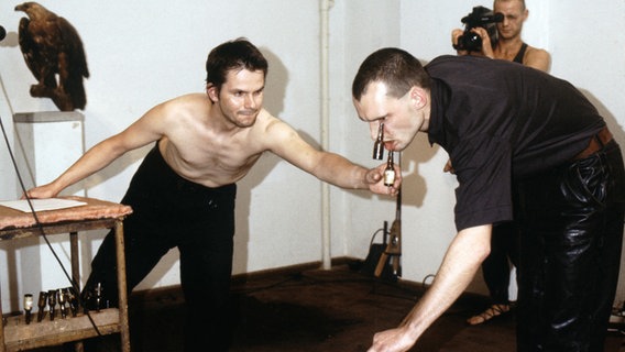 ​​Die Künstler Via Lewandowsky und Durs Grünbein bei der Performance "Deutsche Gründlichkeit" im Jahr 1989. © © für Via Lewandowsky: VG Bild- Kunst, Bonn 2023, © Durs Grünbein Foto: Foto: Jochen Wermann