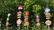 Von Jugendlichen gestaltete Friedenszeichen mit Varusmasken im Park des Museums Kalkriese. © Karoline Kempe 