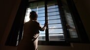Ein weiblicher Häftling vor einem vergitterten Fenster © picture alliance / dpa Foto: Felix Kästle
