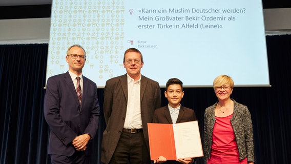 Cornelia Hartwig, Kultusministerium Niedersachsen, (rechts) und Sven Tetzlaff, Leiter Bereich Bildung der Körber-Stiftung, (links) überreichen Efecan Günes (3.v.l.) und dessen Lehrer Dirk Lürssen die Siegerurkunde. © Claudia Höhne Foto: Claudia Höhne