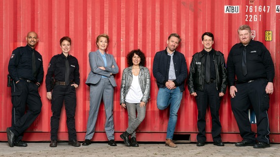 Das Ensemble der Serie "Großstadtrevier" steht in einer Reihe vor einer Containerwand. © © ARD/Thorsten Jander 