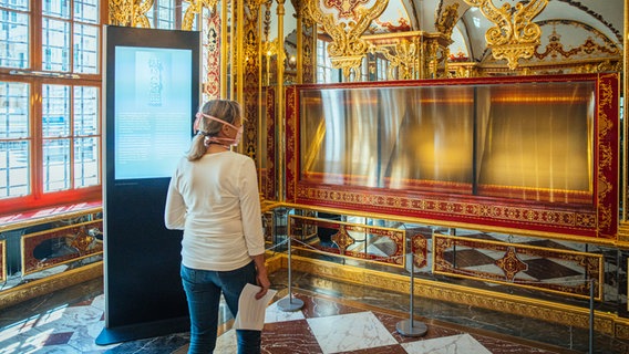 Eine Besucherin schaut in die ausgeraubte und nun ausgestellte Vitrine im Juwelenzimmer des Historischen Grünen Gewölbes im Dresdner Residenzschloss. © picture alliance/dpa/dpa-Zentralbild | Oliver Killig 
