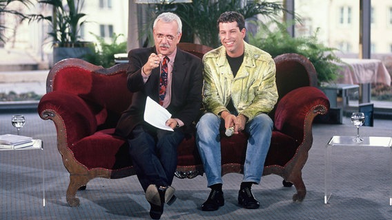 Moderator Geert Mueller-Gerbes (l.) und Thomas Hermanns posieren bei der TV-Sendung "Die Woche" am 22.10.1990 auf einem Sofa. © IMAGOIMAGO Foto: Horst Galuschka