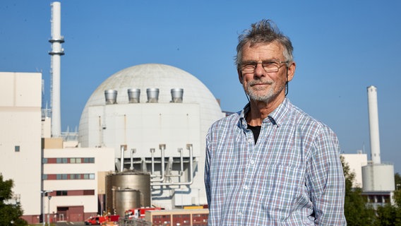 Karsten Hinrichsen, Atomkraftgegner, steht auf einem Deich vor dem Reaktorgebäude des Kernkraftwerks Brokdorf. © picture alliance/dpa Foto: Georg Wendt