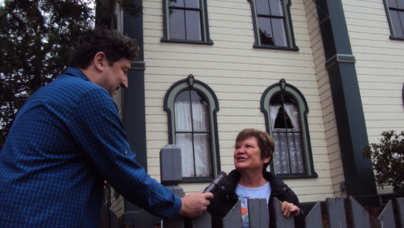 Ein Mann mit Mikrofon interviewt eine Frau vor einem Haus, das für einen Dreh eines Hitchcockfilms in Kalifornien genutzt wurde © NDR Foto: Guido Meyer / Peter Kuttler