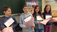 Kinder der Klasse 4d der Schule Alsterredder posieren mit den Texten für ihre Hörspielprodukion in der Hand. © NDR Foto: Janine Lüttmann
