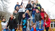 Die Kinder der Klasse 4 der Schule Neuland posieren auf einem Klettergerüst. © NDR Foto: Juliane Bergmann