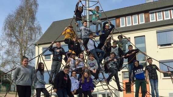 Klasse 6c der Ostseeschule Ückeritz posiert auf einem Klettergerüst. © NDR Foto: Janine Lüttmann