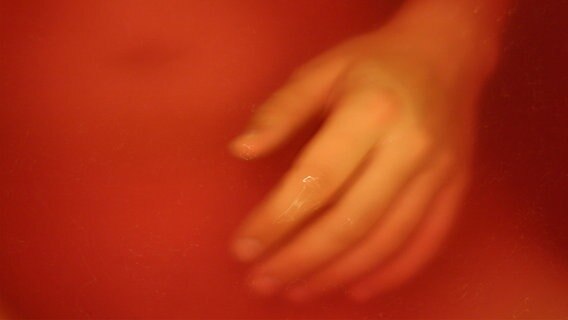 Abbildung einer Hand in einer verschwommenen rötlich gefärbten Umgebung. © Christian Gode / photocase.de Foto: Christian Gode