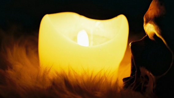Ein Totenkopf wird durch das Licht einer Kerze angestrahlt. © bobot / photocase.de Foto: bobot