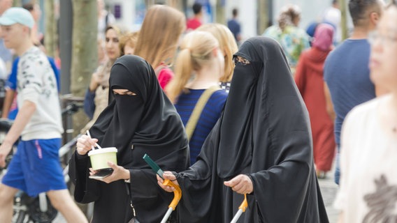 Zwei verschleierte Frauen gehen durch eine Fußgängerzone © imago/photothek 