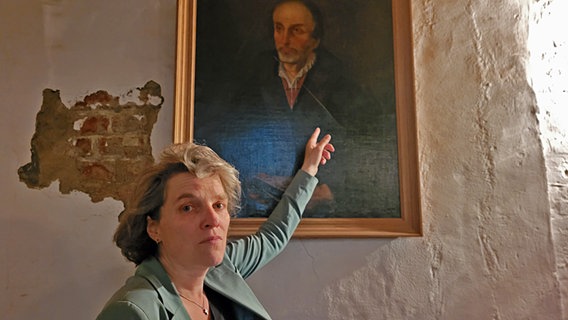 Astrid Kleist zeigt auf ein zerstörtes Bild von Philipp Melanchthon. © NDR Foto: Peter Helling