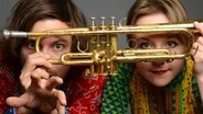Die beiden Mitglieder des Jazzduos Matria halten sich eine Trompete vor die Gesichter. © Susanne Heraucourt Foto: Susanne Heraucourt