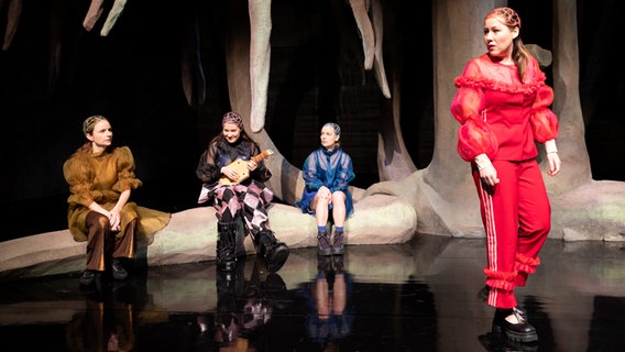 Die vier Darstellerinnen des Stücks "Johanna" sitzen und stehen auf der Bühne, eine von ihnen hält ein Saiteninstrument in den Händen. © Sinje Hasheider 