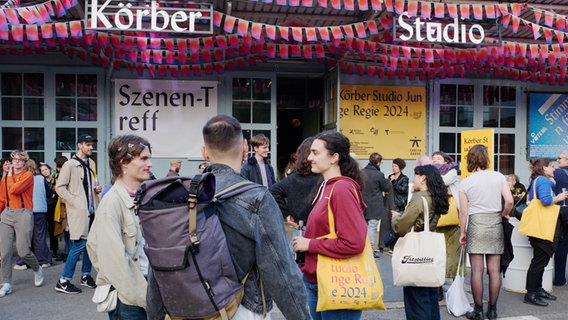 Eine große Gruppe von jungen Leuten steht vor einem bunt geschmückten Gebäude-Eingang. © Körber Stiftung / Fabian Hammerl 