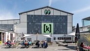 Die Halle der Kulturfarbrik Kampnagel in Hamburg mit einem großen Logo, das den Buchstaben K in Klammern zeigt. © picture alliance/dpa | Markus Scholz Foto: Markus Scholz