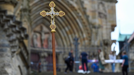 Ein Jesuskreuz auf einem Stab steht vor dem Erfurter Dom. © Heiko Rebsch/dpa 