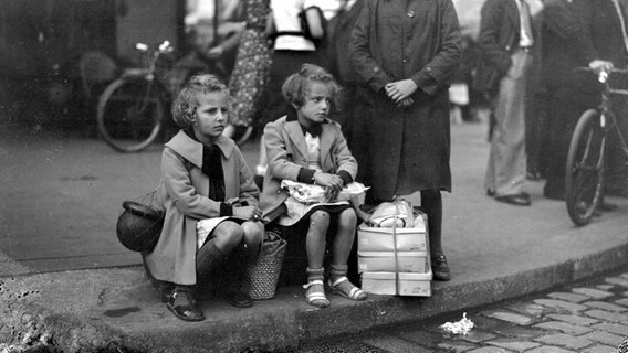 Zwei Mädchen sitzen auf Koffern © Roger Viollet via Getty Images 