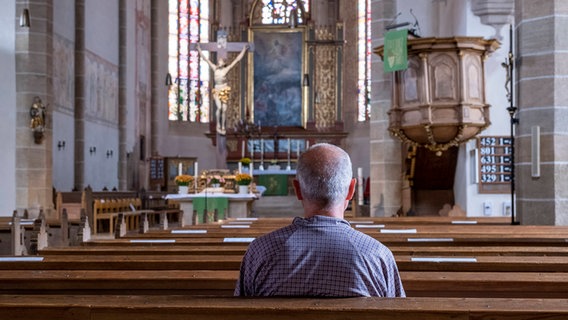 Ein älterer Mann sitzt alleine in der Kirche © imago 