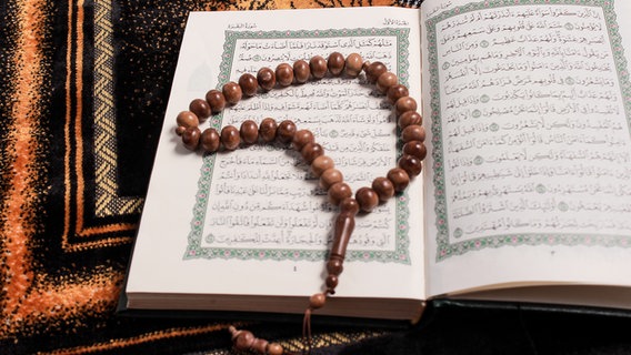 Junger Mann hält den Koran eng umschlungen. © picture alliance / Golden Pixels LLC 