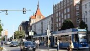 Der Blick von der Fußgängerzone auf die Lange Straße in Rostock. Mitten durch fahren Autos und es hält eine Straßenbahn. © picture alliance/Bernd Wüstneck/dpa-Zentralbild/dpa Foto: Bernd Wüstneck