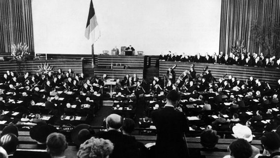 Das Bild zeigt die feierliche Eröffnung des ersten Deutschen Bundestages in Bonn durch den Alterspräsidenten Paul Löbe (am Rednerpult). © picture alliance / dpa 