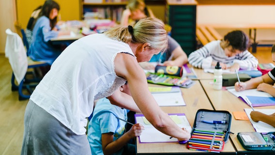 Eine Lehrerin hilft den Schülern einer vierten Klasse im Unterricht. © picture alliance/dpa | Frank Molter 