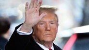 Donald Trump, Präsidentschaftskandidat und ehemaliger Präsident der USA hält eine verschmierte Hand hoch. © dpa-Bildfunk/AP/dpa Foto: Seth Wenig