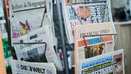Verschiedene Zeitungen stecken in einem Zeitungsständer © picture alliance/dpa Foto: Annette Riedl