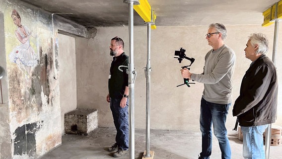 Pawel Sawicki, Pressereferent und Museumsführer in der Gedenkstätte Auschwitz, zeigt dem Filmteam Wandbilder in den Kellern des ehemaligen KZ. © MDR/Chris Blokhuis 