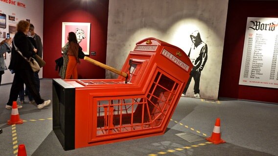 Eines der bekanntesten Bilder von Banksy in der Hamburger Ausstellung: Die Telefonzelle mit Axt © NDR Foto: Patricia Batlle