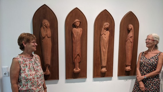 Vier hochformatige Terrakotten des Künstlers Ernst Barlach, rechts und links daneben stehen zwei Frauen, die die Kunstwerke lächelnd anschauen. © Katja Bülow /NDR Foto: Katja Bülow