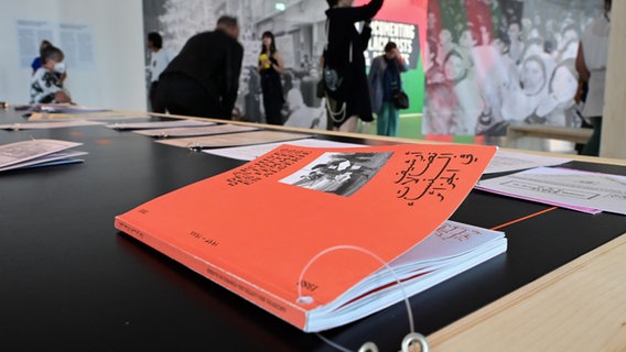 Auf einem Tisch liegt eine rote Broschüre des "Archives des luttes des femmes en Algérie" © picture alliance/dpa | Uwe Zucchi 