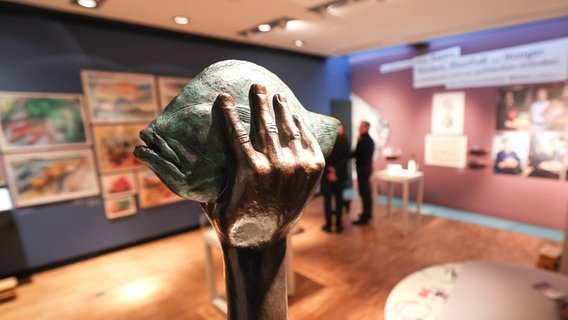 Eine Skulptur von Günter Grass mit einem Butt in der Hand in der Ausstellung "Grass kocht" im Günter Grass Haus in Lübeck © Christian Charisius/dpa-Bildfunk + Foto: Christian Charisius