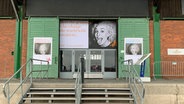 Ein Lagerschuppen im Hamburger Hafen, an dem Plakate hängen © ADC 