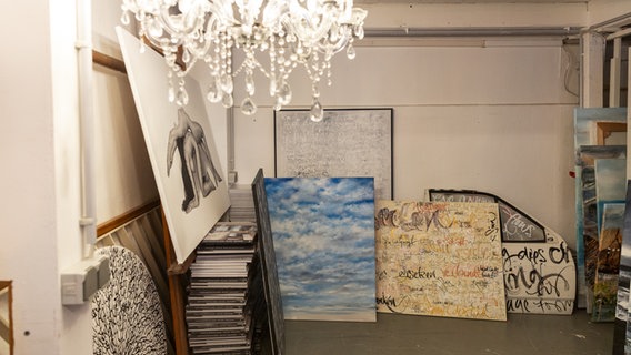 Gemälde und gestapelte Bücher im Atelier von Jeannine Platz © NDR.de Foto: Christina Grob