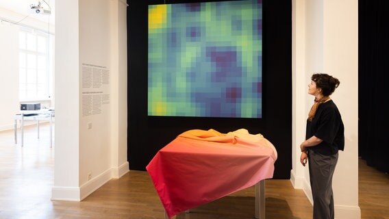 Eine Frau schaut auf ein farbiges Quadrat in der Ausstellung "Can you hear it". © Museum für Kunst und Gewerbe / Daniel Müller Foto: Daniel Müller