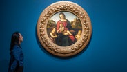 Frau betrachtet Bildnis der Madonna in einer Ausstellung © picture alliance / Photoshot 