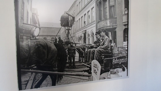Ein Foto zeigt einen Mann und einen Jungen, die auf einem Kutschbock sitzen, dahinter Männer mit einer großen Filmkamera © Axel Seitz 