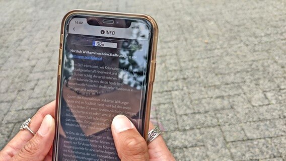 Auf einem Handy läuft eine App mit Infos zum postkolonialen Erbe in Göttingen Auf einem Handy läuft eine App mit Infos zum postkolonialen Erbe in Göttingen © NDR Foto: Frederik Schulz-Greve