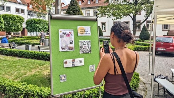 Lara Krause betrachtet Infotafeln am Wilhelmplatz vom Projekt der Geschichte des postkolonialen Erbes in Göttingen Lara Krause betrachtet Infotafeln am Wilhelmplatz vom Projekt der Geschichte des postkolonialen Erbes in Göttingen © NDR Foto: Frederik Schulz-Greve