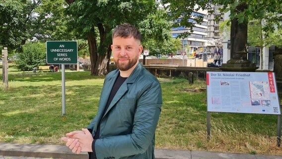 Ein Mann steht vor einem Schild mit der Aufschrift: "An unnecessary series of words". Ein Mann steht vor einem Schild mit der Aufschrift: "An unnecessary series of words". © Agnes Bührig Foto: Agnes Bührig