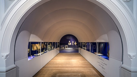Ein Blick in einen tunnelartigen Raum mit Schauvitrinen in der Ausstellung über jüdische Geschichte im Landesmuseum Braunschweig © Landesmuseum Braunschweig 