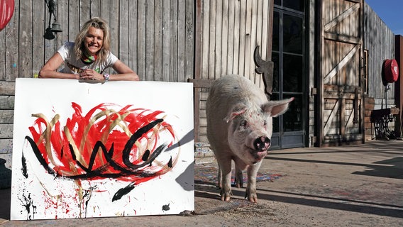 Halterin und Schweinedame Pigcasso posieren mit Gemälde © dpa-Bildfunk Foto: Kristin Palitza/dpa
