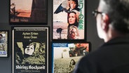 Der Filmemacher und Kurator der Ausstellung "Helma Sanders-Brahms · ihre Filme, ihr Leben", Ayhan Salar, schaut auf Filmplakate zu Werken von Helma Sanders-Brahms. © dpa Foto: Lennart Stock