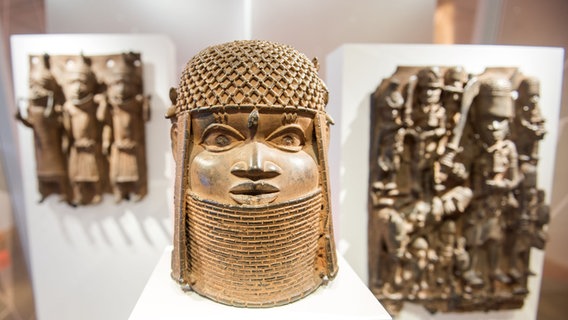 Drei Raubkunst-Bronzen aus dem Land Benin in Westafrika sind im Museum für Kunst und Gewerbe (MKG) in einer Vitrine ausgestellt. © picture alliance/dpa Foto: Daniel Bockwoldt