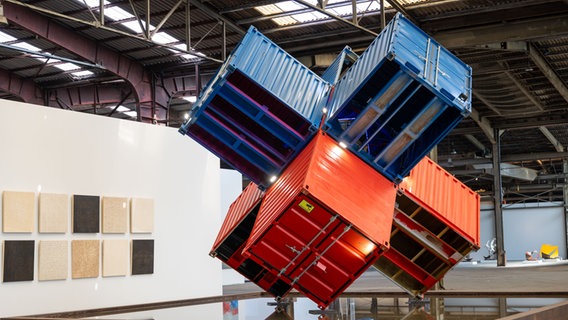 Vier Container sind in einer Industriehalle zu einem Kunstwerk mit einander verbunden. © NordArt / Wohlfromm 