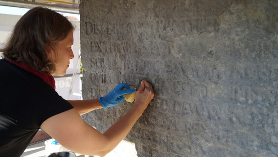 Stephanie Silligmann bearbeitet die fast 430 Jahre alte Inschrift.  Foto: Nadine Gräser