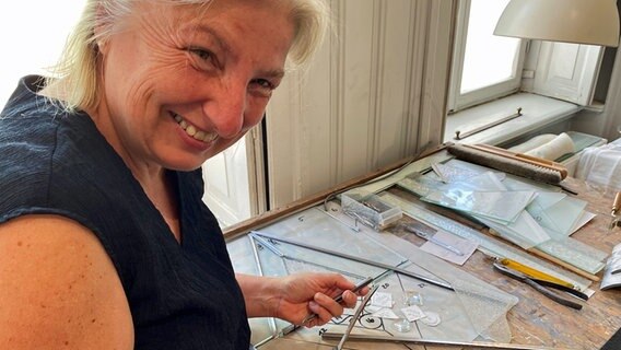 Glasrestauratorin  Eva-Maria Ziegler steht in ihrem Atelier in Lübeck und arbeitet an einem bleiverglasten Fenster. © NDR Foto: Linda Ebener